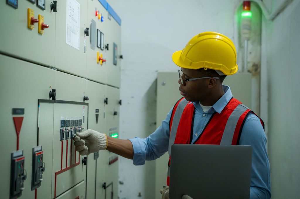 Engineer working in electrical control room,operator station network in industry factory,Switchgear.